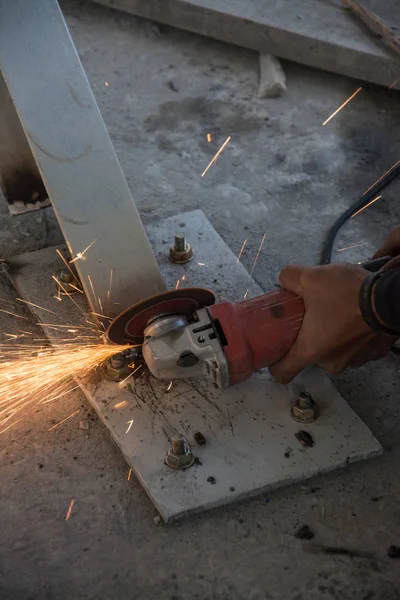 Arbeiter schneidet mit einem elektrischen Gerät ein Metallrohr — Stockfoto