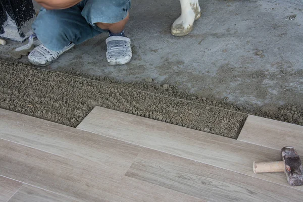 Laying ceramic wood tiles on wall, installing tiles  in construction site. — Stock Photo, Image