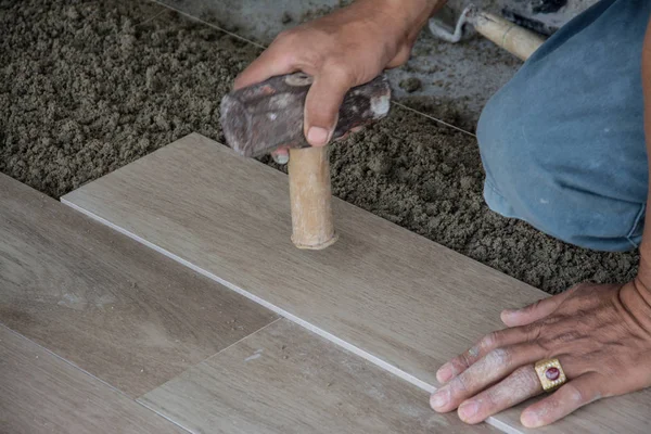 Laying ceramic wood tiles on wall, installing tiles  in construction site. — Stock Photo, Image