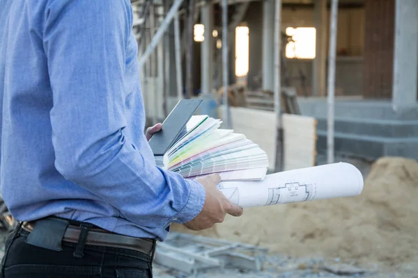 Ingeniero constructor con plano en el sitio de construcción — Foto de Stock