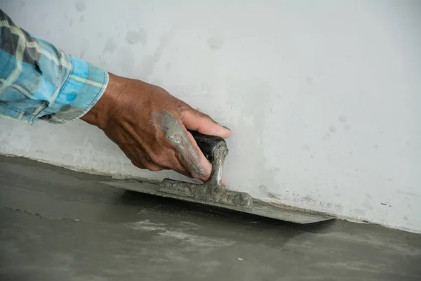 Gipszmunkás betonmunkás a ház padlóján — Stock Fotó