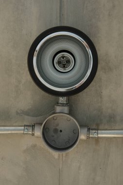 Beton tavan altında metal boru ile modern lamba