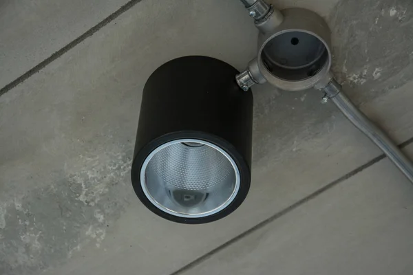 Lampe moderne avec tuyau métallique sous le plafond en béton — Photo