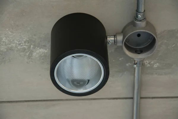 Lámpara moderna con tubo de metal bajo el techo de hormigón —  Fotos de Stock