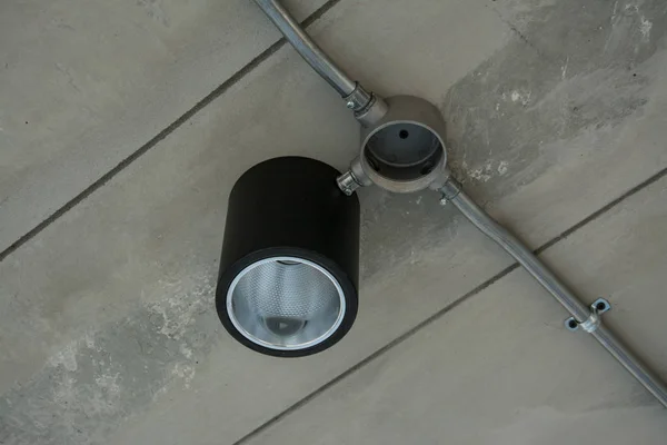 Современная лампа с металлической трубой под бетонным потолком — стоковое фото
