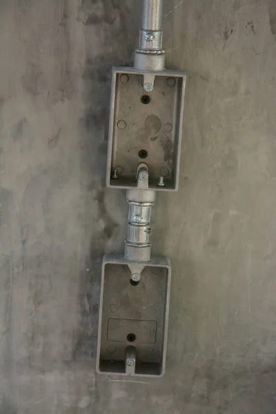 Электрическая система на стене на строительной площадке, розетка с железом — стоковое фото