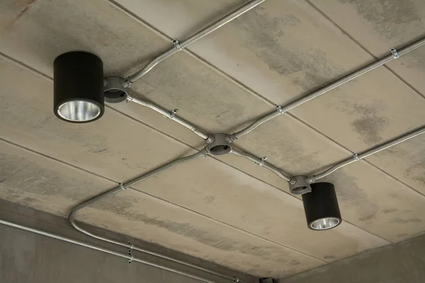 Lámpara moderna con tubo de metal bajo el techo de hormigón — Foto de Stock