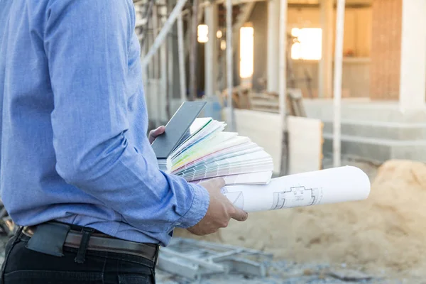 Ingeniero constructor con plano en el sitio de construcción — Foto de Stock