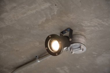 Beton tavan altında metal boru ile modern lamba