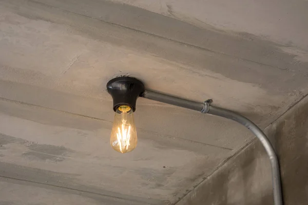 Lámpara moderna con tubo de metal bajo el techo de hormigón —  Fotos de Stock