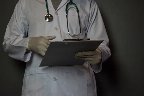 医生在黑色背景上记笔记。医学的概念 — 图库照片