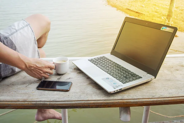 Lavoro in terrazza. uomo che lavora sul computer portatile mentre seduto su legno — Foto Stock