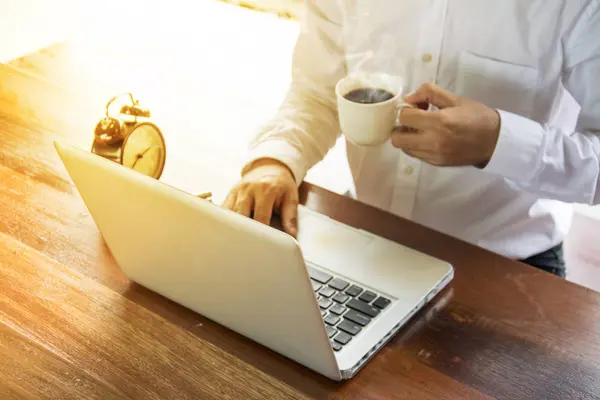 Uomo d'affari che lavora con laptop, documenti e caffè su legno — Foto Stock