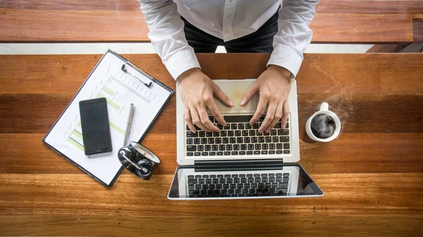 Top view of business man working  with laptop ,documents and cof