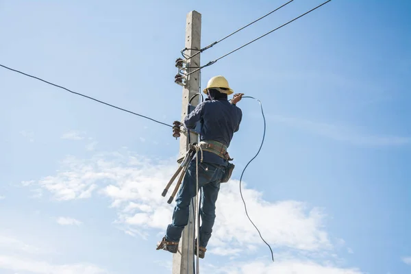 Electricista trabajando en poste de energía eléctrica con cielo azul —  Fotos de Stock