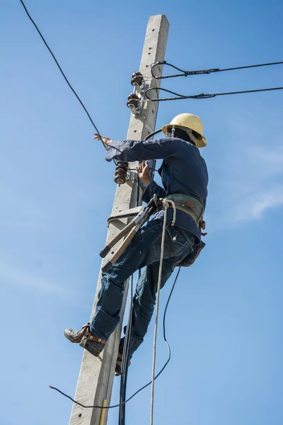 Electricista trabajando en poste de energía eléctrica con cielo azul —  Fotos de Stock