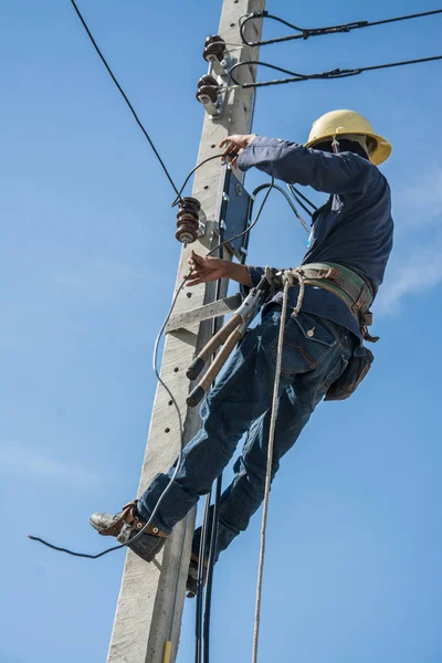 Electricista trabajando en poste de energía eléctrica con cielo azul —  Fotos de Stock