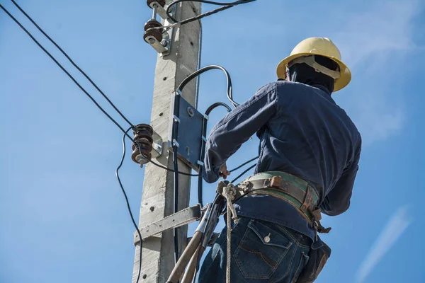 Electricista trabajando en poste de energía eléctrica con cielo azul —  Fotos de Stock
