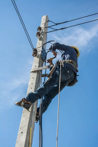 Electricista trabajando en poste de energía eléctrica con cielo azul —  Fotos de Stock