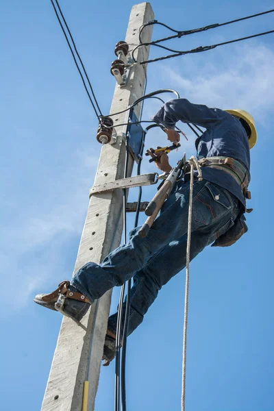 Electricista trabajando en poste de energía eléctrica con cielo azul —  Fotos de Stock