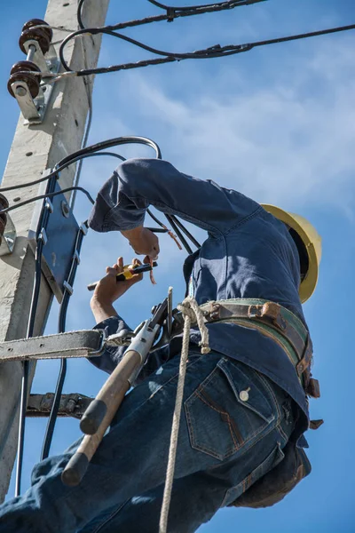 Electricista trabajando en poste de energía eléctrica con cielo azul —  Fotos de Stock