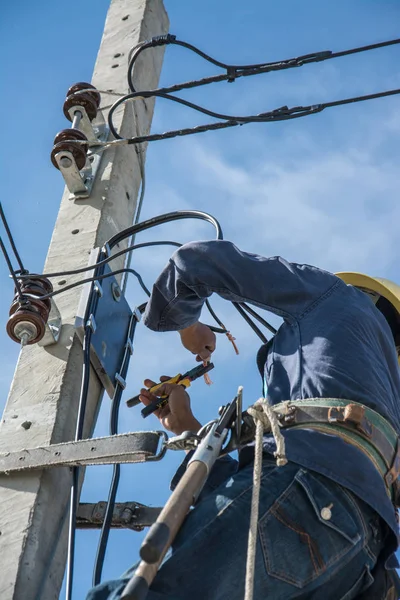 Electricista trabajando en poste de energía eléctrica con cielo azul —  Fotos de Stock