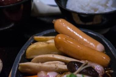 sosis sıcak tava üzerinde mantar ile ateş.