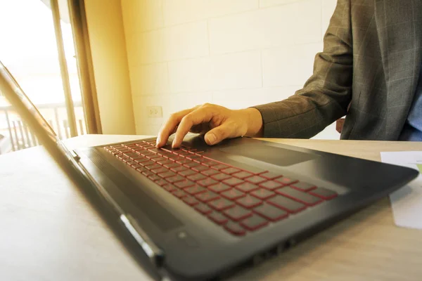 Uomo d'affari che lavora con laptop e documenti su tavolo in legno — Foto Stock