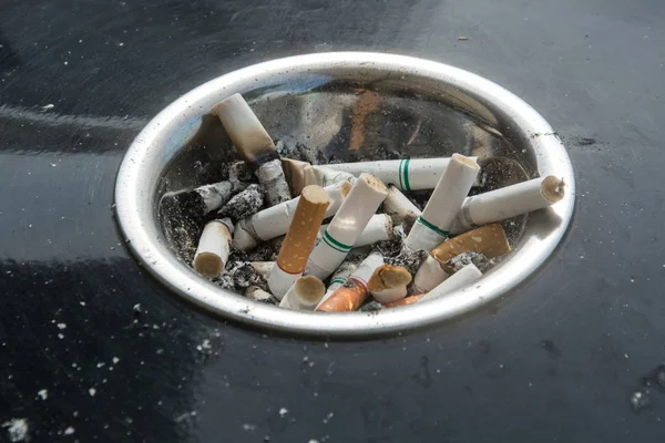 Kupie papierosy wiele korki, Niedopałki papierosów w popielniczka — Zdjęcie stockowe
