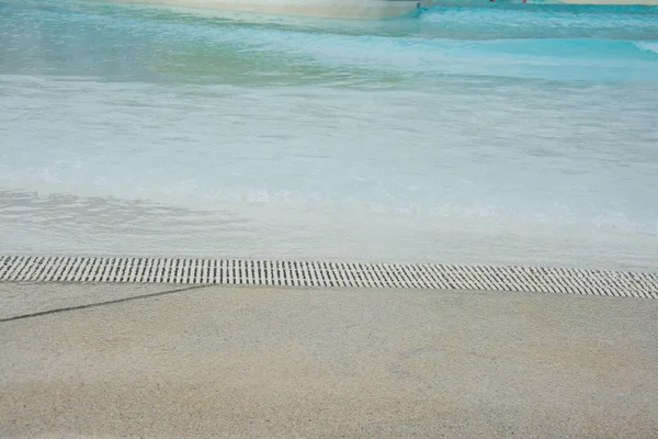 Piscine d'eau avec caniveau et plage de sable — Photo