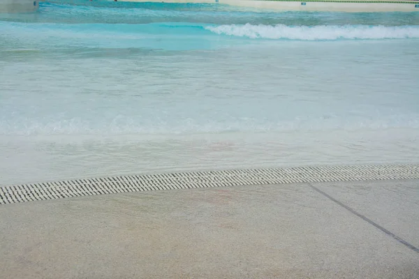 Piscine d'eau avec caniveau et plage de sable — Photo