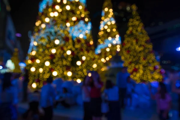 Rozmazané pozadí abstraktní chůze lidí s vánoční lig — Stock fotografie
