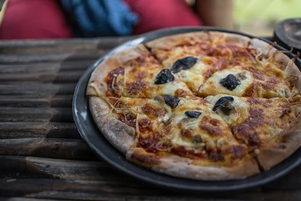 Wegetariańskie pizza z pieczarkami na drewnianym stole — Zdjęcie stockowe