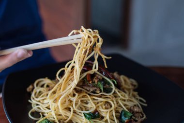 Sai Aua (Notrhern Tay Sp ile tavada kızartılmış spagetti yiyen Kadın