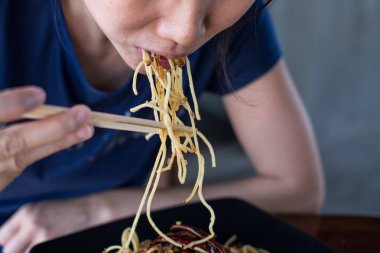 Sai Aua (Notrhern Tay Sp ile tavada kızartılmış spagetti yiyen Kadın