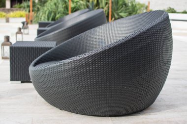 Otelde havuzun yanında rattan bir yatak.