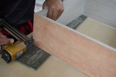 Marangoz yeni mobilya yapmak için havalı silah kullanır. 