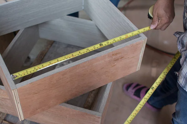 using tape measure for measuring size of wooden furniture