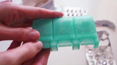 Kadın, Medicine Organizatör 'ü beyaz ve kahverengi haplarla açıp, Masa Makro' yu...