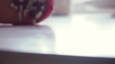 Kadın beyaz masanın üzerine beyaz ve kahverengi hapları atıyor. Makro, kapat.