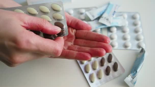 Vrouw neemt twee pillen bij de hand en grijpt het. Sluiten. — Stockvideo