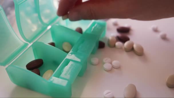 Kobieta oddziela białe i brązowe pigułki do leku Organizator Makro zbliżenie — Wideo stockowe