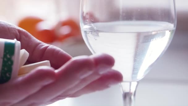 Woman takes Vitamin C pill to hand and putting it into glass of water. Close up — Stock Video