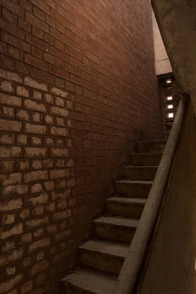 Narrow staircase of stone inside of a brick house