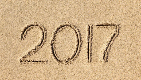 new year 2017 written in sand