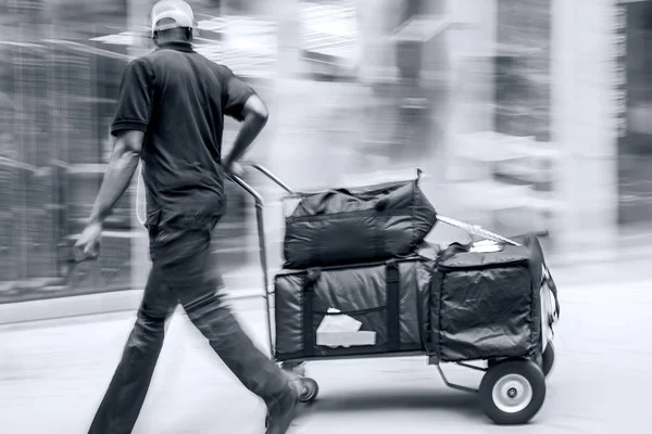 Delivery with dolly by hand in monochrome blue tonality — Stock Photo, Image