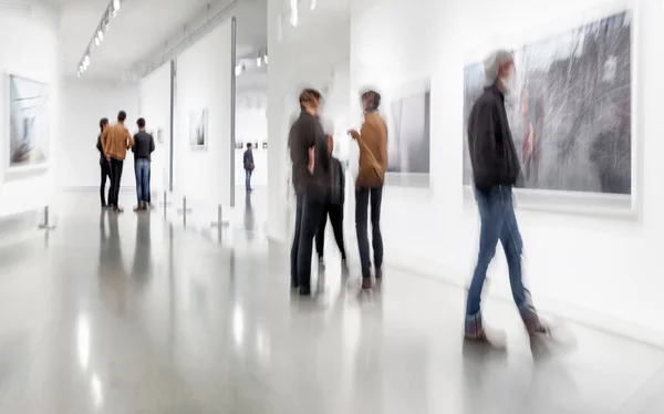 背景がぼやけている現代美術センターのロビーにいる人々の抽象的なイメージです — ストック写真