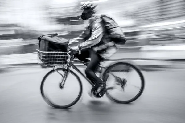 雨の日に街中の道路を自転車で行き来する仮面のビジネスマンが — ストック写真