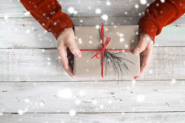 Bir Noel hediyesi tutan bir kırmızı kazaklı kadın — Stok fotoğraf