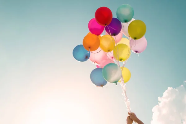 Menina segurando balões multicoloridos — Fotografia de Stock